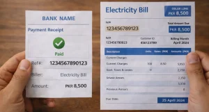 A close up of Pakistani hands holding a bank payment receipt and a printed electricity bill side by side, reference numbers visible on both documents, wooden desk background.